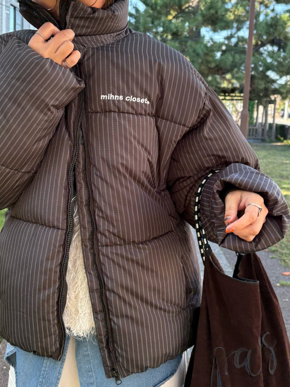 その他のダウンジャケット/コート、ブラック系のスニーカー、ブルー系のシャツ/ブラウスを着用したレディースの秋コーディネートの4枚目の写真