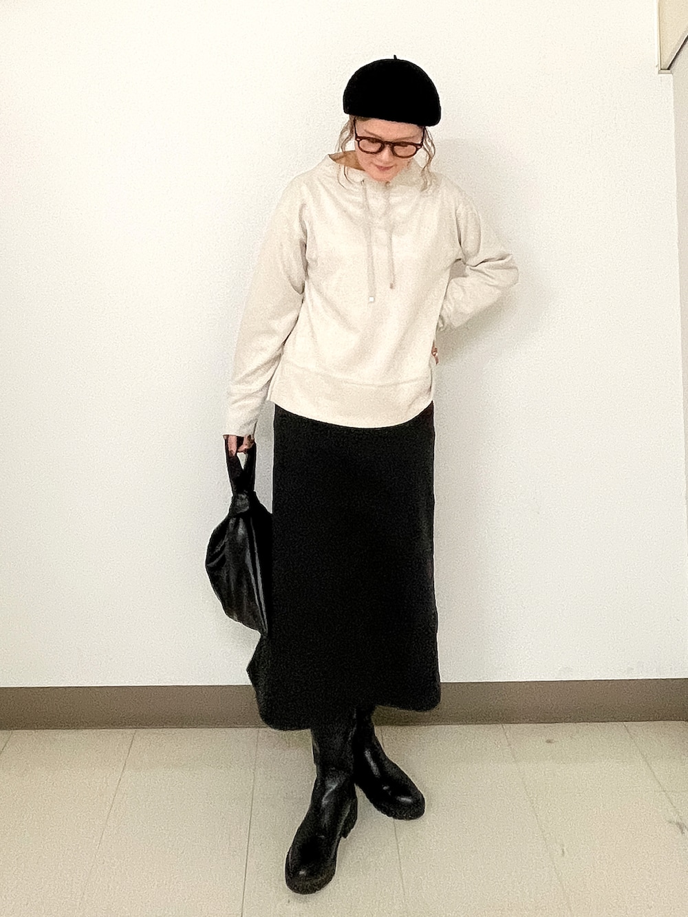 ベージュ系のスウェット、ブラック系のスカート、ブラック系のチェスターコートを着用したレディースの秋コーディネートの2枚目の写真