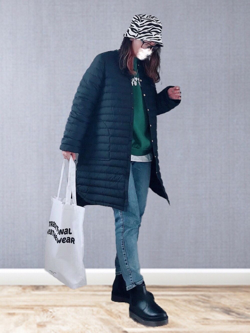 ブラック系のダウンジャケット/コート、グリーン系のスウェット、ホワイト系のTシャツ/カットソーを着用したレディースの冬コーディネートの2枚目の写真