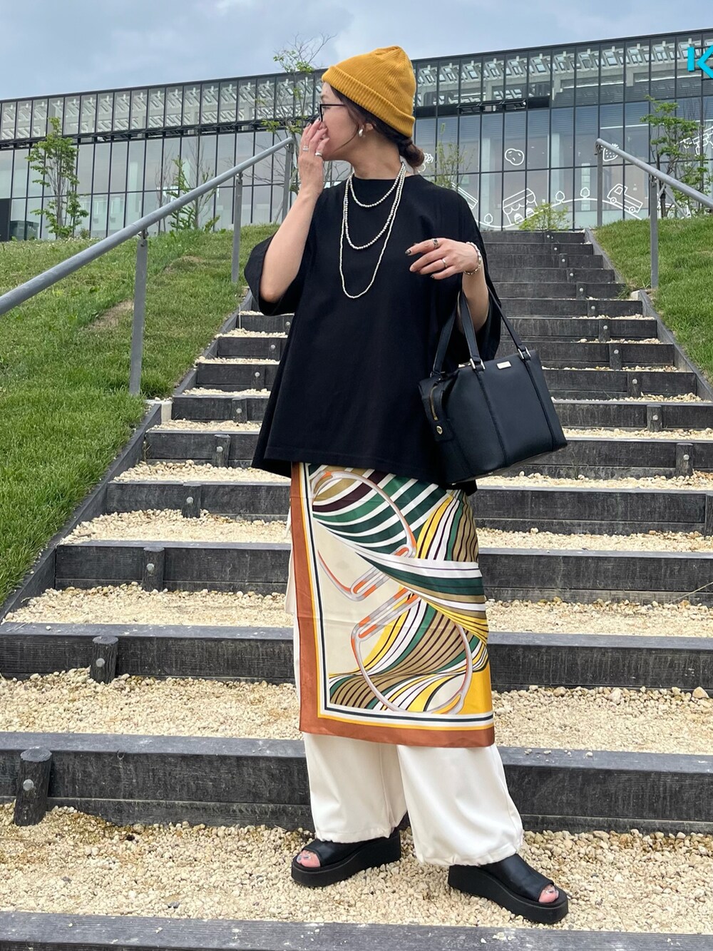 ブラック系のTシャツ/カットソー、ホワイト系のその他パンツ、ブラック系のサンダルを着用したレディースの夏コーディネートの5枚目の写真