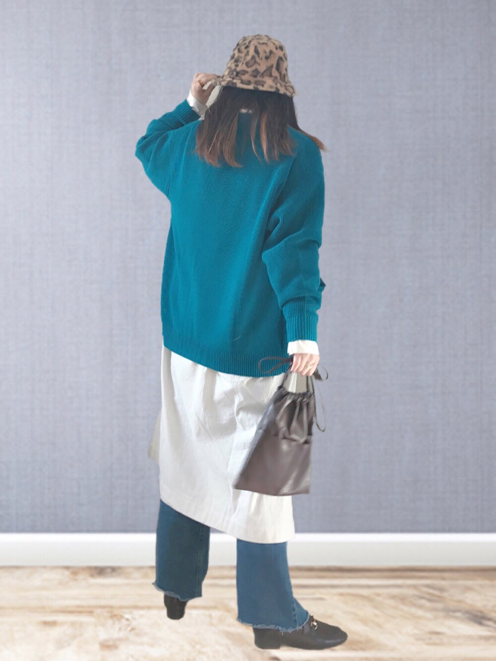 ブルー系のカーディガン/ボレロ、ブルー系のデニムパンツ、ブラウン系のハンドバッグを着用したレディースの冬コーディネートの3枚目の写真