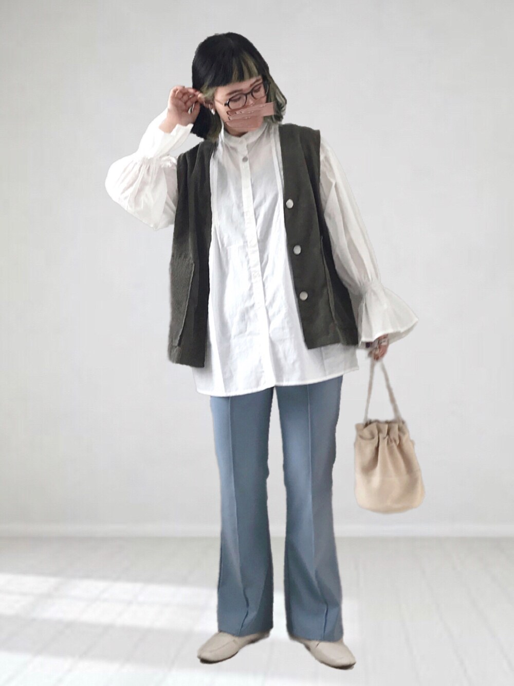 ホワイト系のシャツ/ブラウス、ブルー系のその他パンツ、グリーン系のベストを着用したレディースの冬コーディネートの3枚目の写真