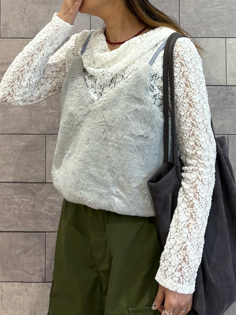 グレー系のトートバッグ、ホワイト系のTシャツ/カットソー、グリーン系のカーゴパンツを着用したレディースの冬コーディネートの4枚目の写真