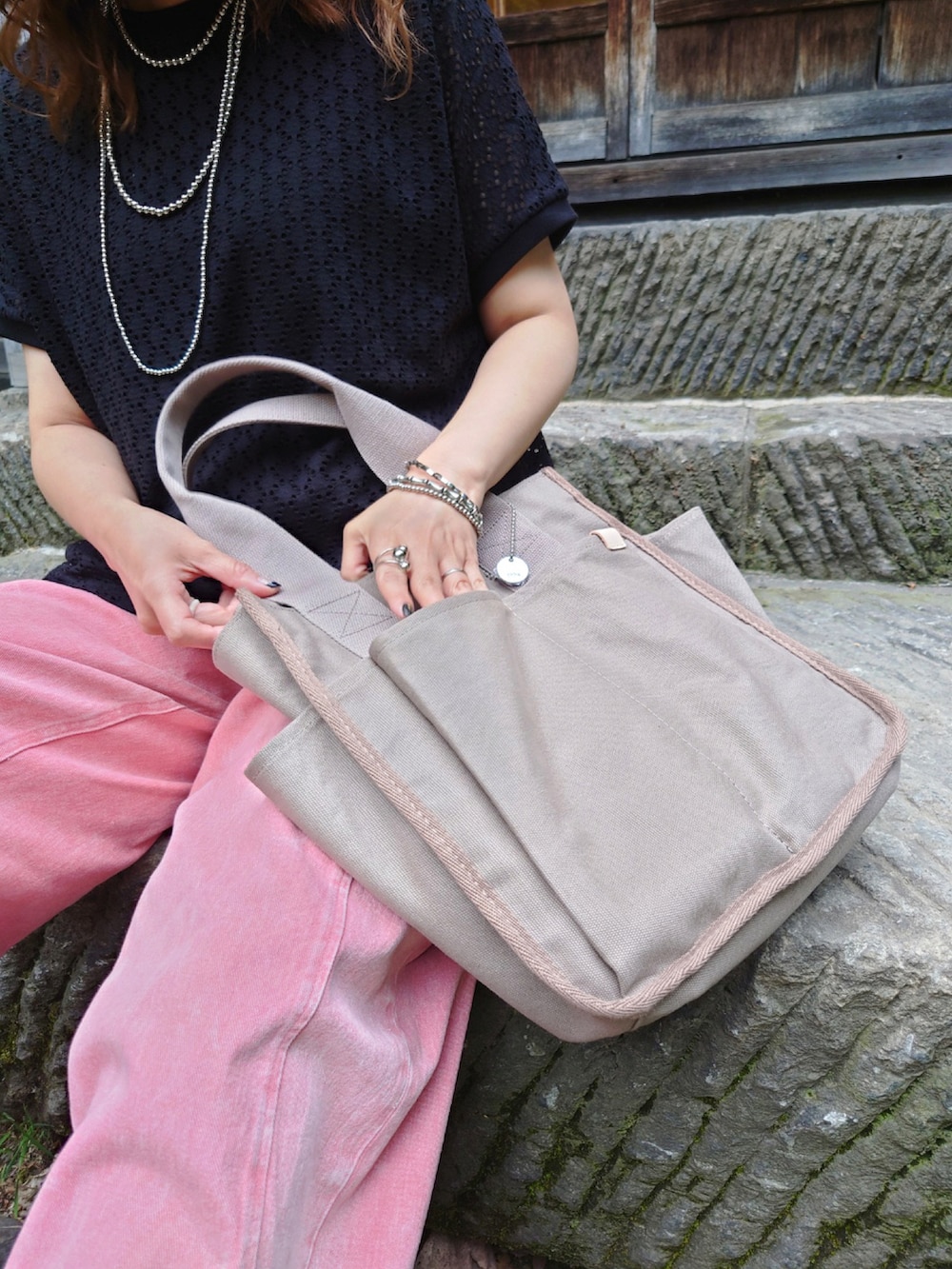 ブラック系のTシャツ/カットソー、ベージュ系のトートバッグ、ピンク系のデニムパンツを着用したレディースの夏コーディネートの4枚目の写真