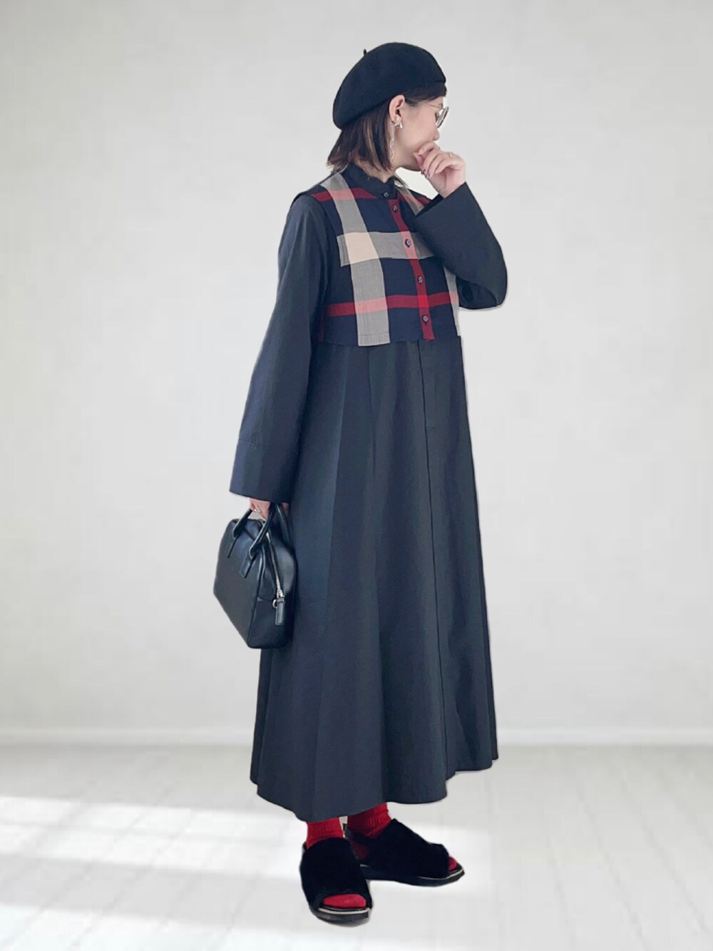 ブラック系のワンピース、ブラック系のボストンバッグ、ブラック系のサンダルを着用したレディースの秋コーディネートの2枚目の写真