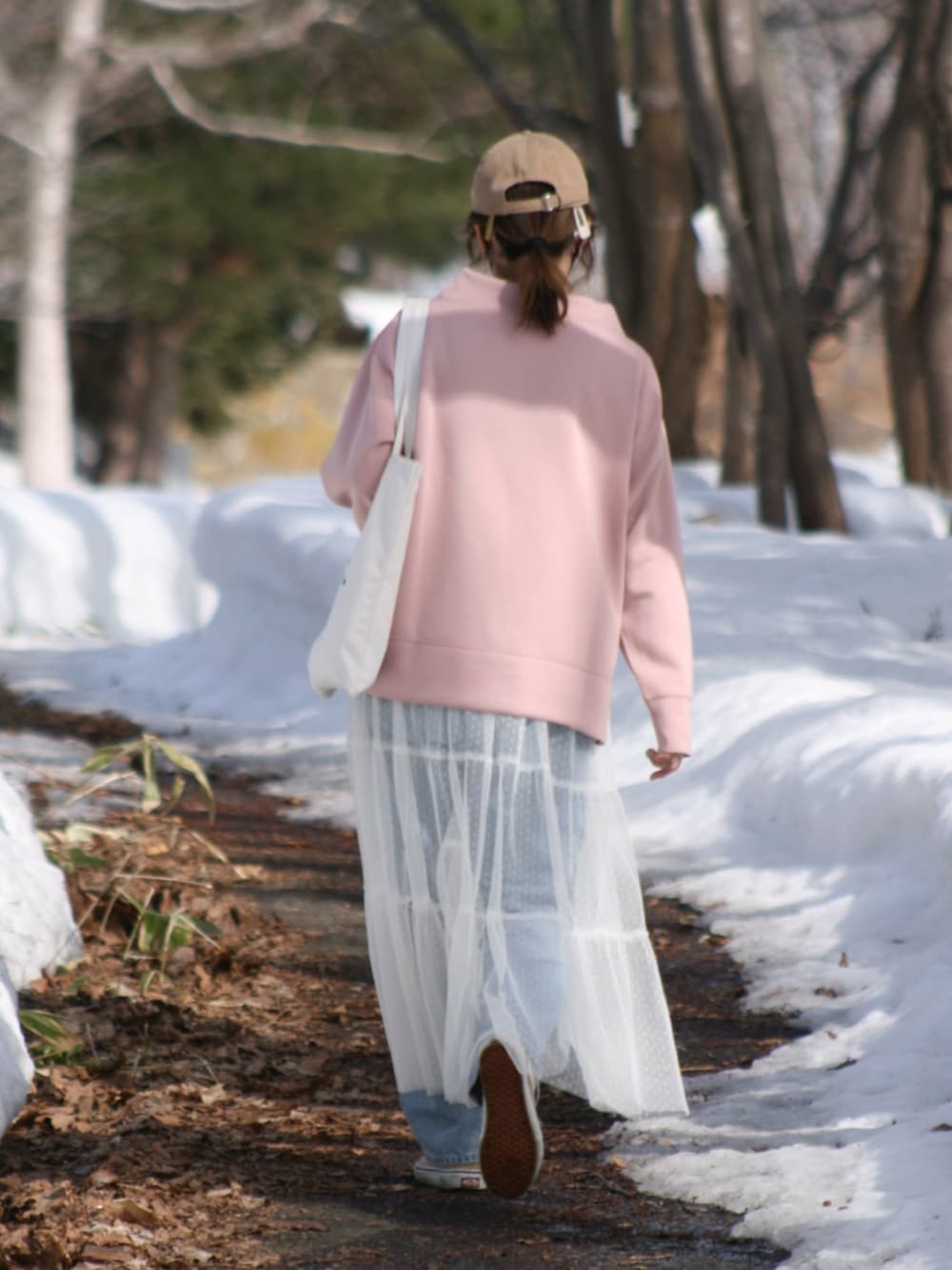 ピンク系のスウェット、ブルー系のデニムパンツ、ホワイト系のワンピース/ドレスを着用したレディースの春コーディネートの3枚目の写真