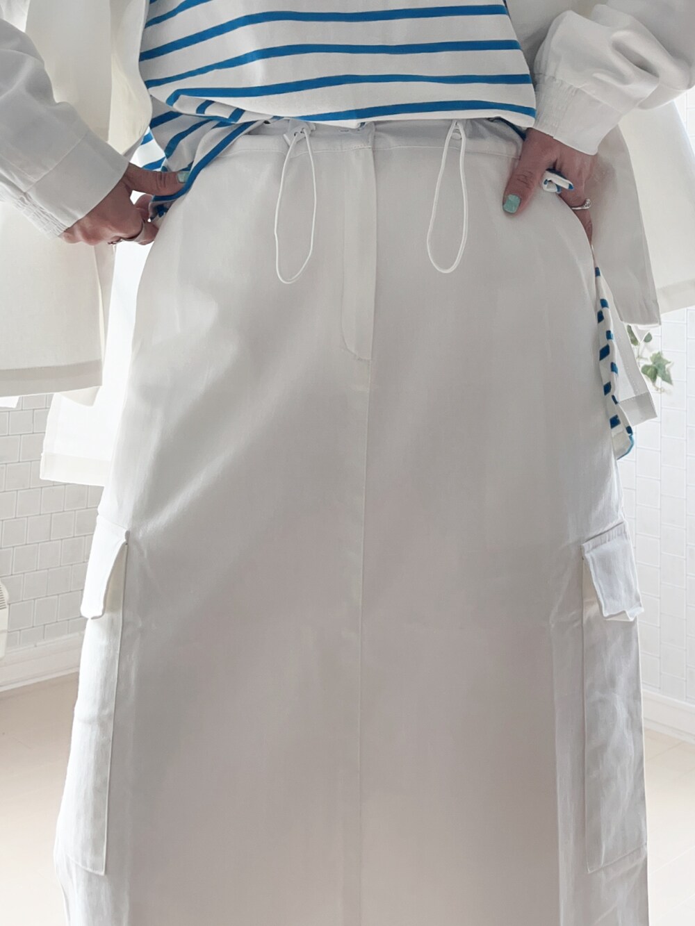 ホワイト系のその他トップス、ホワイト系のスカート、ブルー系のTシャツ/カットソーを着用したレディースの春コーディネートの5枚目の写真