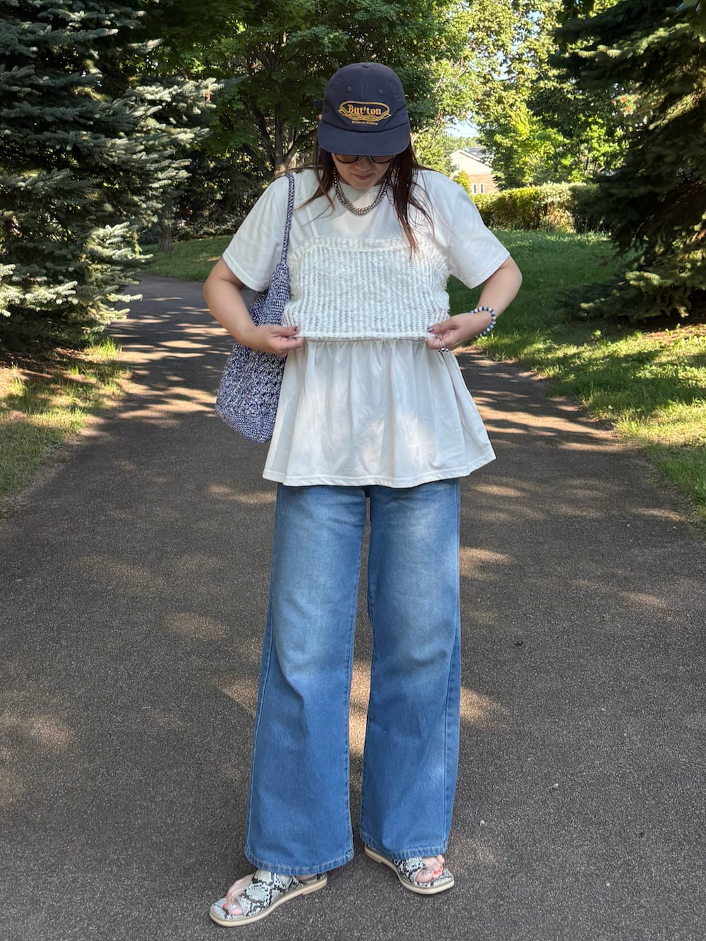グレー系のTシャツ/カットソー、ブルー系のかごバッグ、ブルー系のデニムパンツを着用したレディースの夏コーディネートの5枚目の写真
