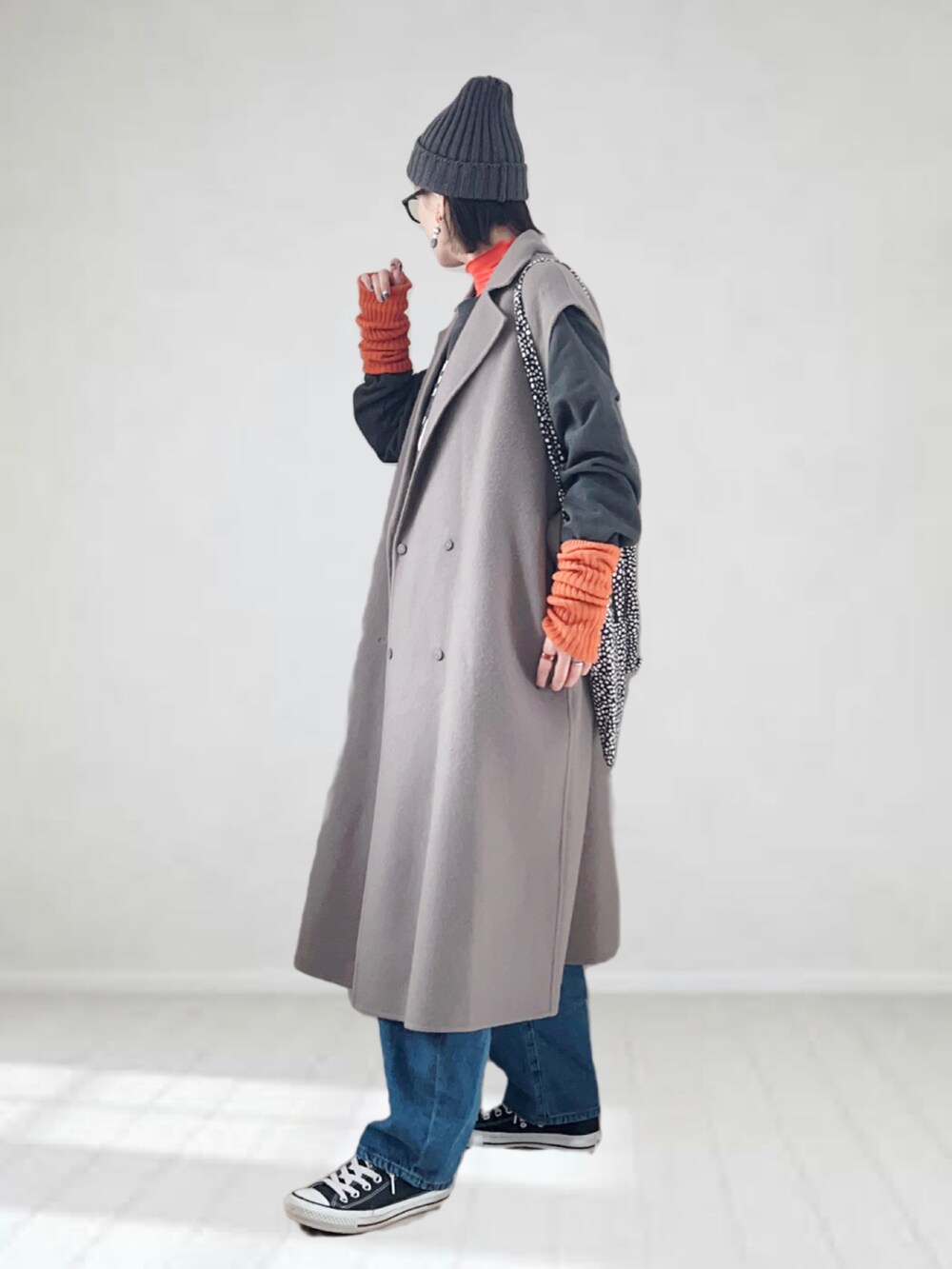 ブラウン系のチェスターコート、オレンジ系のTシャツ/カットソー、グレー系のスウェットを着用したレディースの冬コーディネートの3枚目の写真