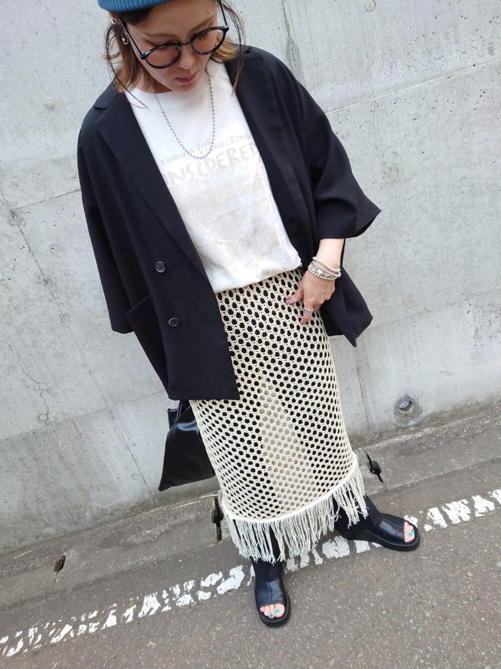 ブラック系のテーラードジャケット、ホワイト系のTシャツ/カットソー、ホワイト系のスカートを着用したレディースの夏コーディネートの4枚目の写真