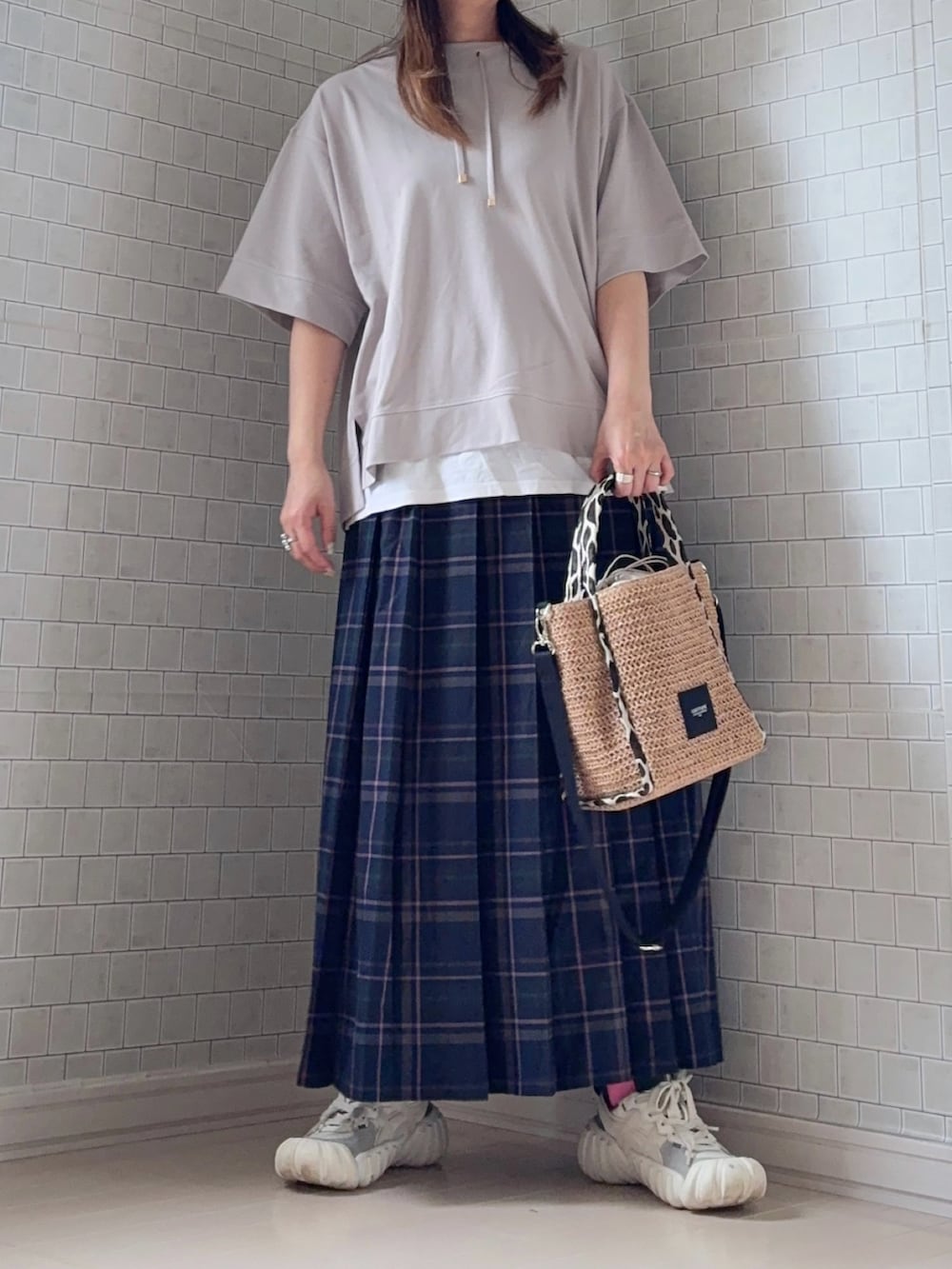グレー系のTシャツ/カットソー、イエロー系のショルダーバッグ、ブルー系のスカートを着用したレディースの春コーディネートの4枚目の写真