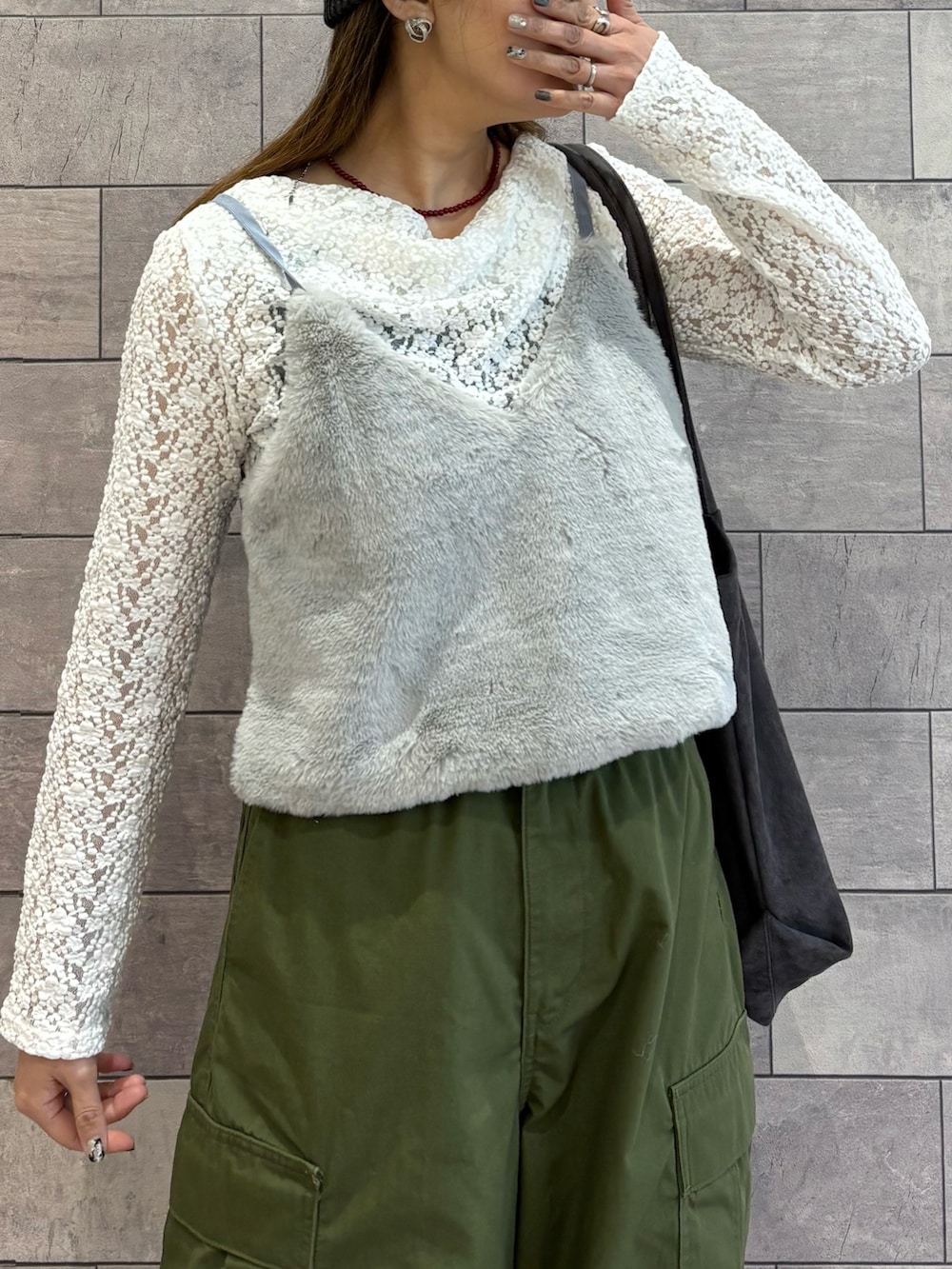 グレー系のトートバッグ、ホワイト系のTシャツ/カットソー、グリーン系のカーゴパンツを着用したレディースの冬コーディネートの3枚目の写真