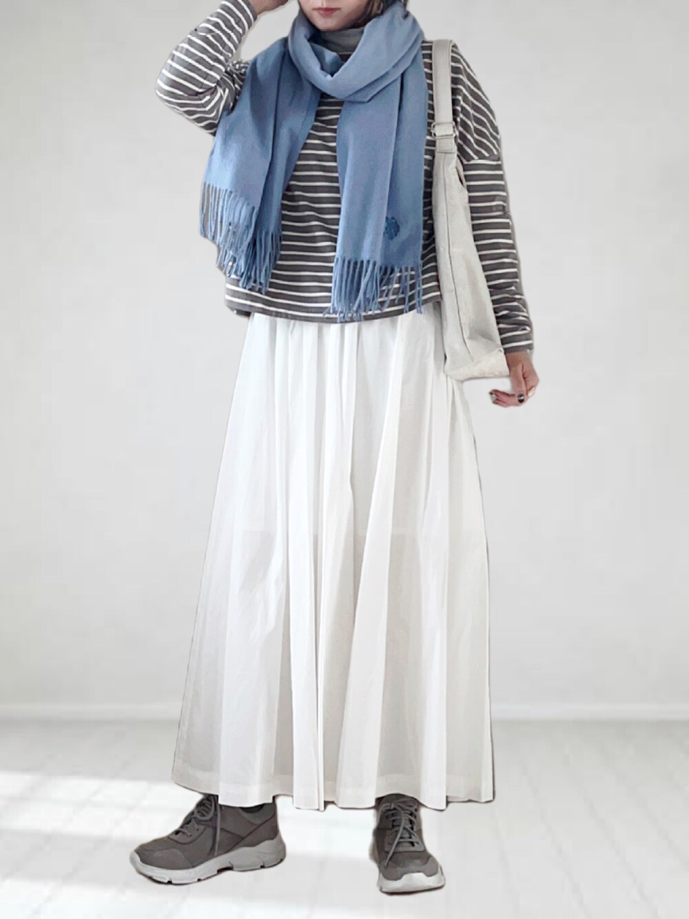 グレー系のTシャツ/カットソー、ホワイト系のダウンジャケット/コート、グレー系のスニーカーを着用したレディースの秋コーディネートの3枚目の写真