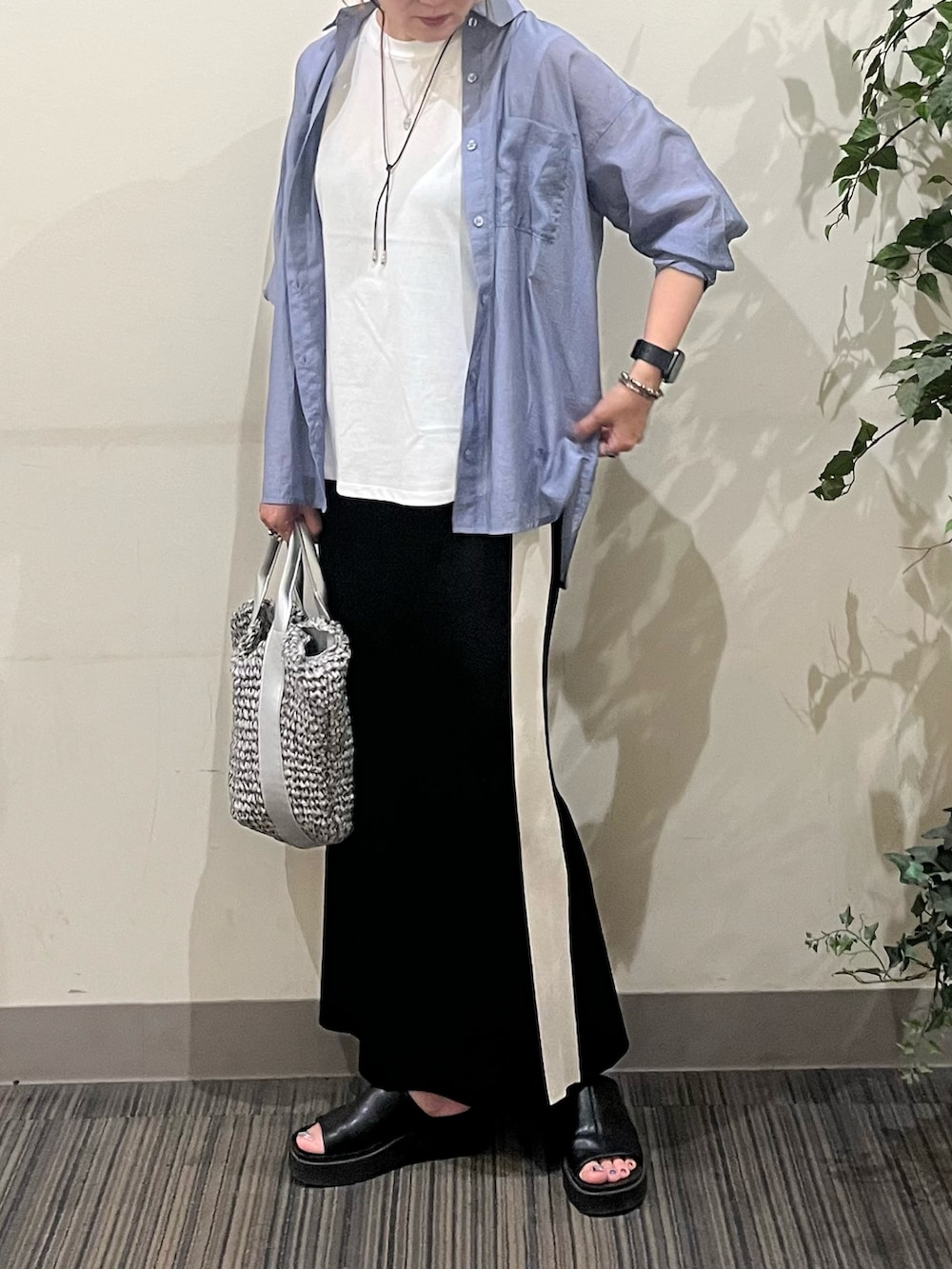 ブラック系のスカート、グレー系のショルダーバッグ、ブラック系のサンダルを着用したレディースの夏コーディネートの2枚目の写真