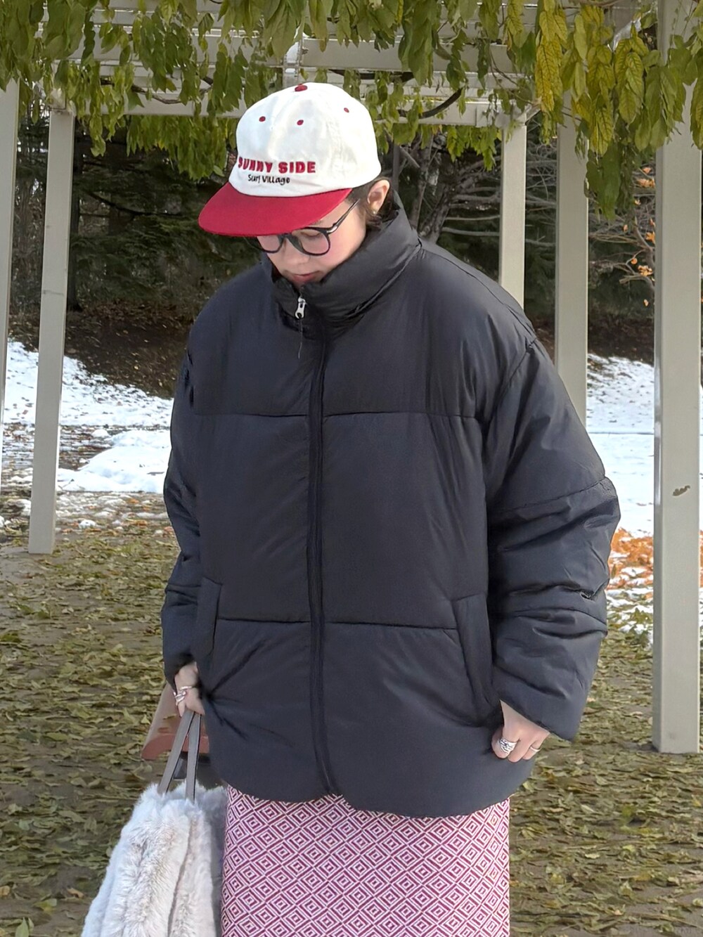 ブラック系のダウンジャケット/コート、ベージュ系のショルダーバッグ、ブラック系のブーツを着用したレディースの冬コーディネートの4枚目の写真