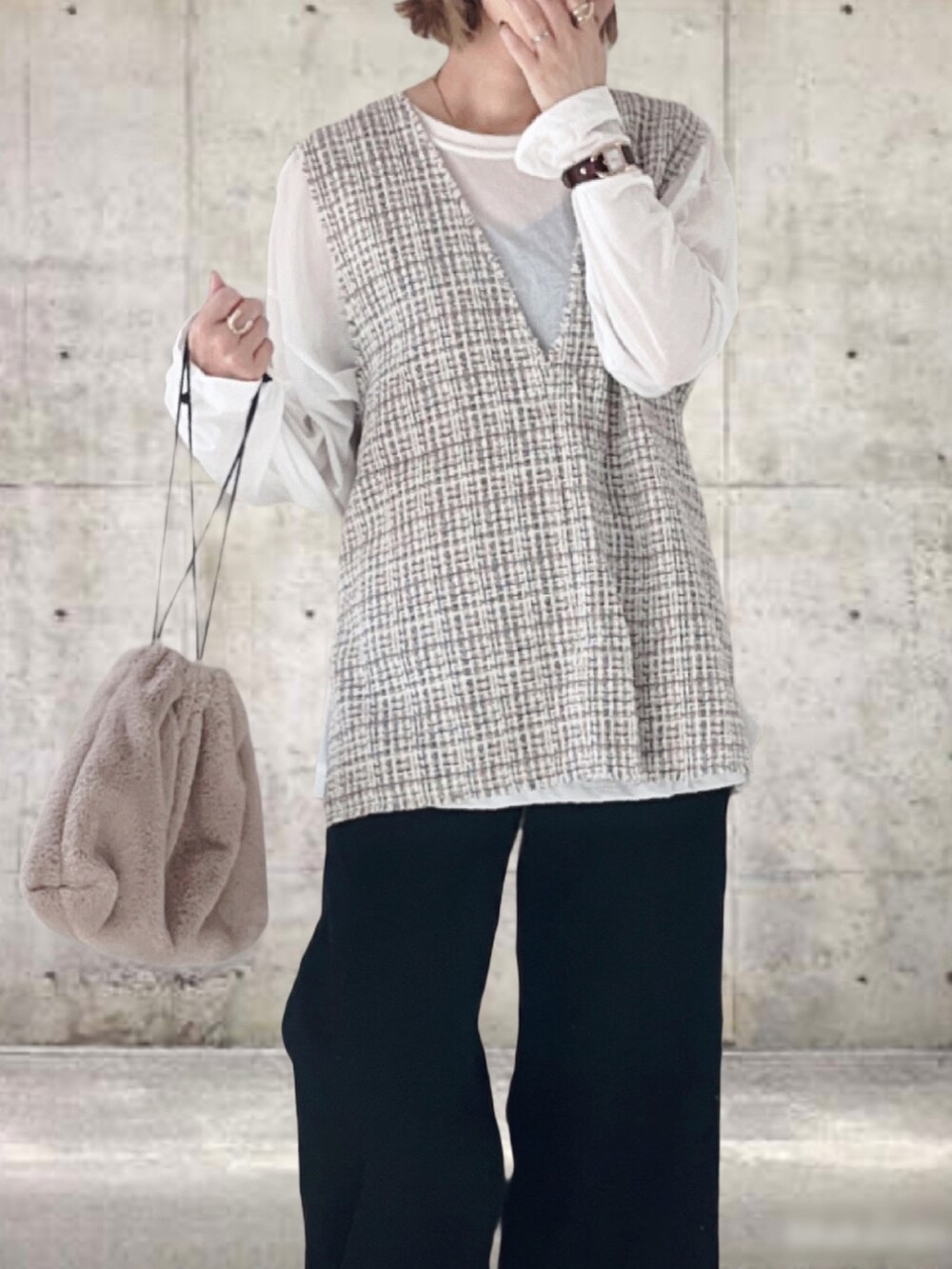 ホワイト系のベスト、ホワイト系のTシャツ/カットソー、ブラック系のデニムパンツを着用したレディースの秋コーディネートの2枚目の写真