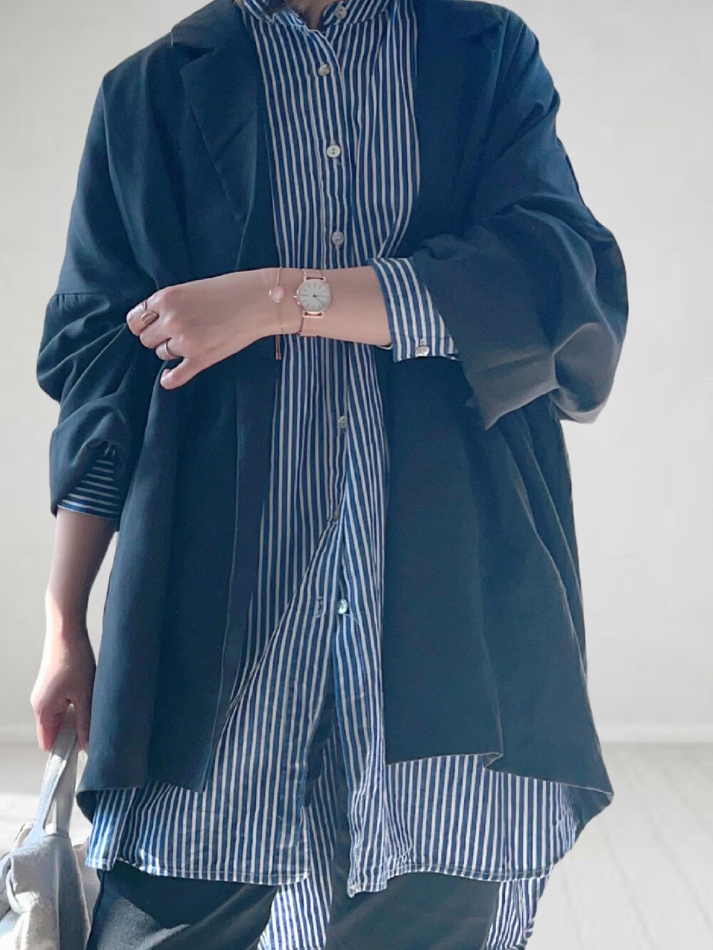 グレー系のテーラードジャケット、ブルー系のシャツ/ブラウス、ブラック系のデニムパンツを着用したレディースの春コーディネートの2枚目の写真