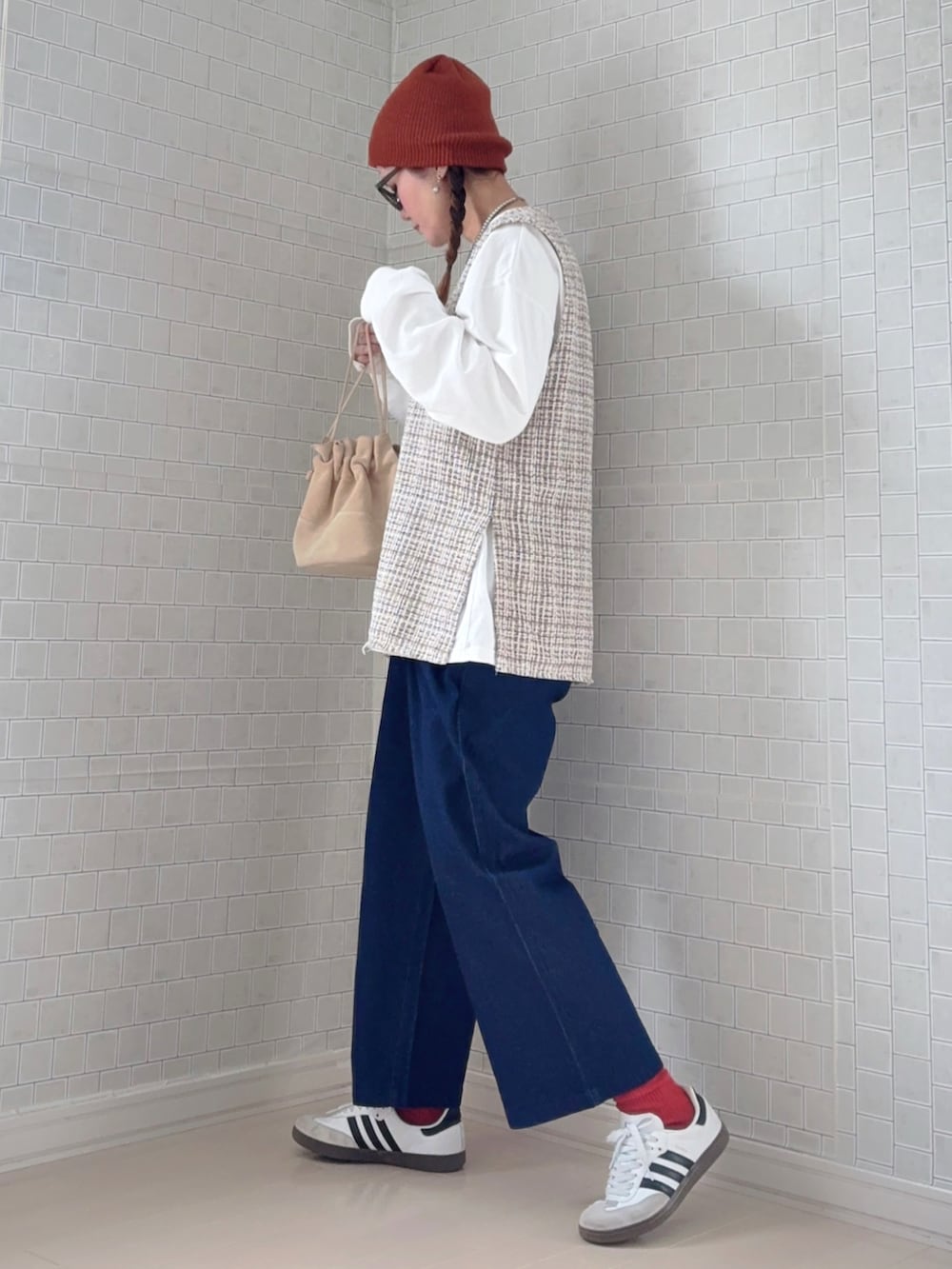 ブルー系のチノパンツ、ホワイト系のスニーカー、ブラウン系のニットキャップ/ビーニーを着用したレディースの冬コーディネートの2枚目の写真