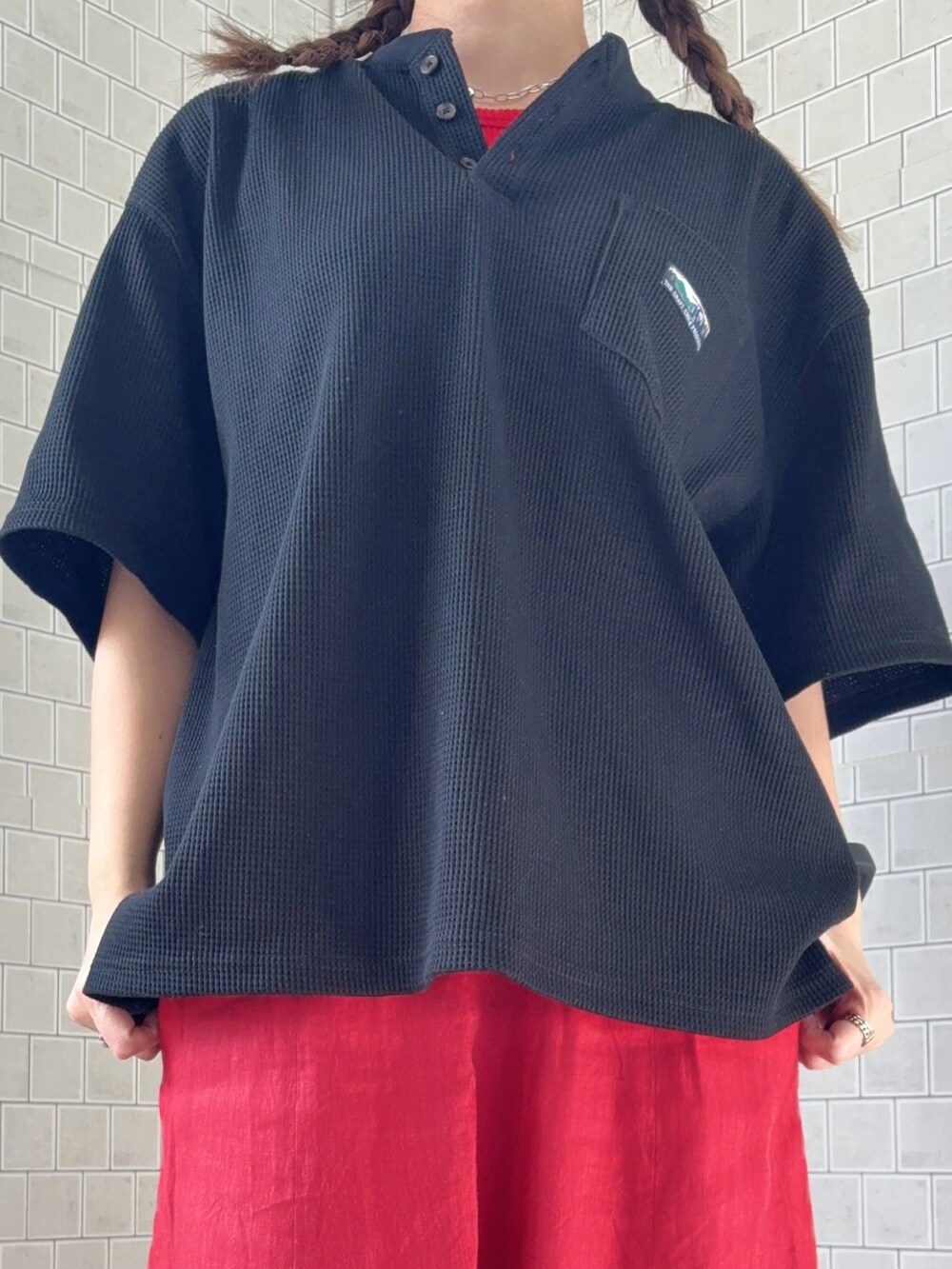 ブラック系のTシャツ/カットソー、ホワイト系のスニーカー、レッド系のキャップを着用したレディースの春コーディネートの4枚目の写真