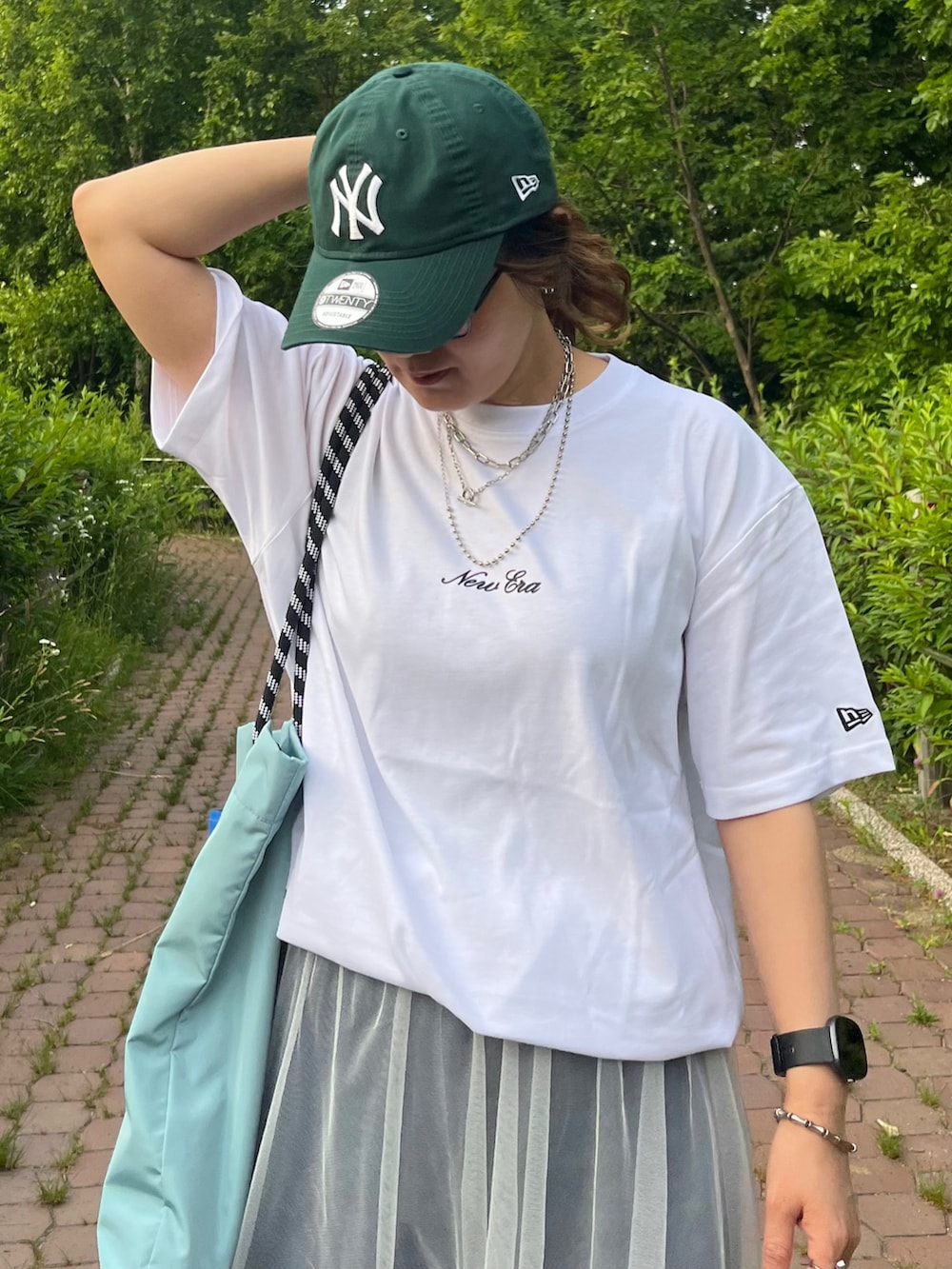 ホワイト系のTシャツ/カットソー、ブルー系のデニムパンツ、ホワイト系のスカートを着用したレディースの夏コーディネートの3枚目の写真