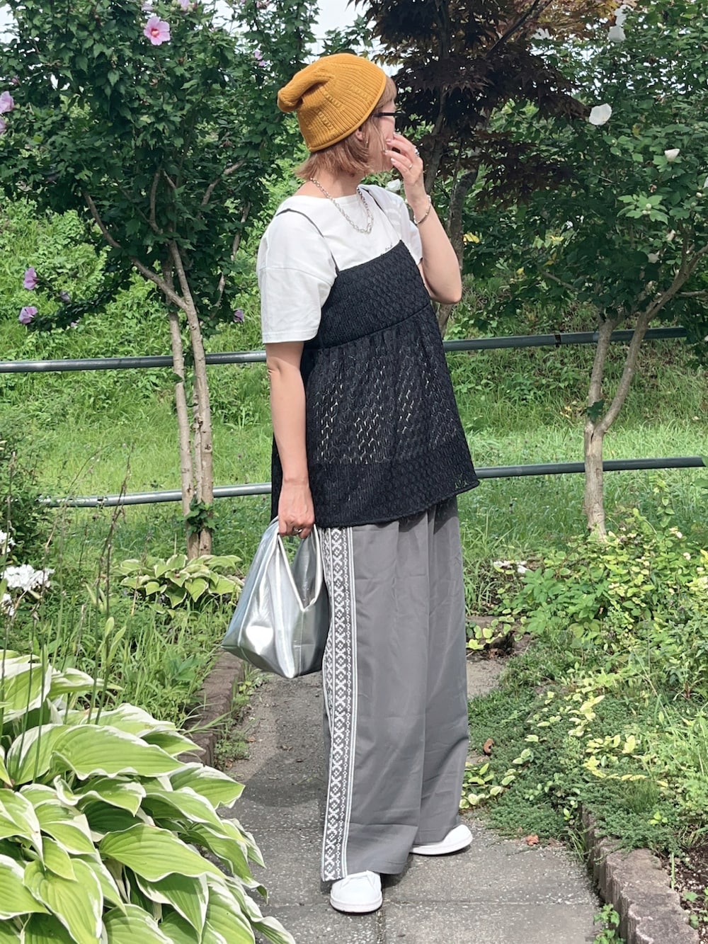 グレー系のその他パンツ、ブラック系のTシャツ/カットソー、ホワイト系のスニーカーを着用したレディースの夏コーディネートの4枚目の写真