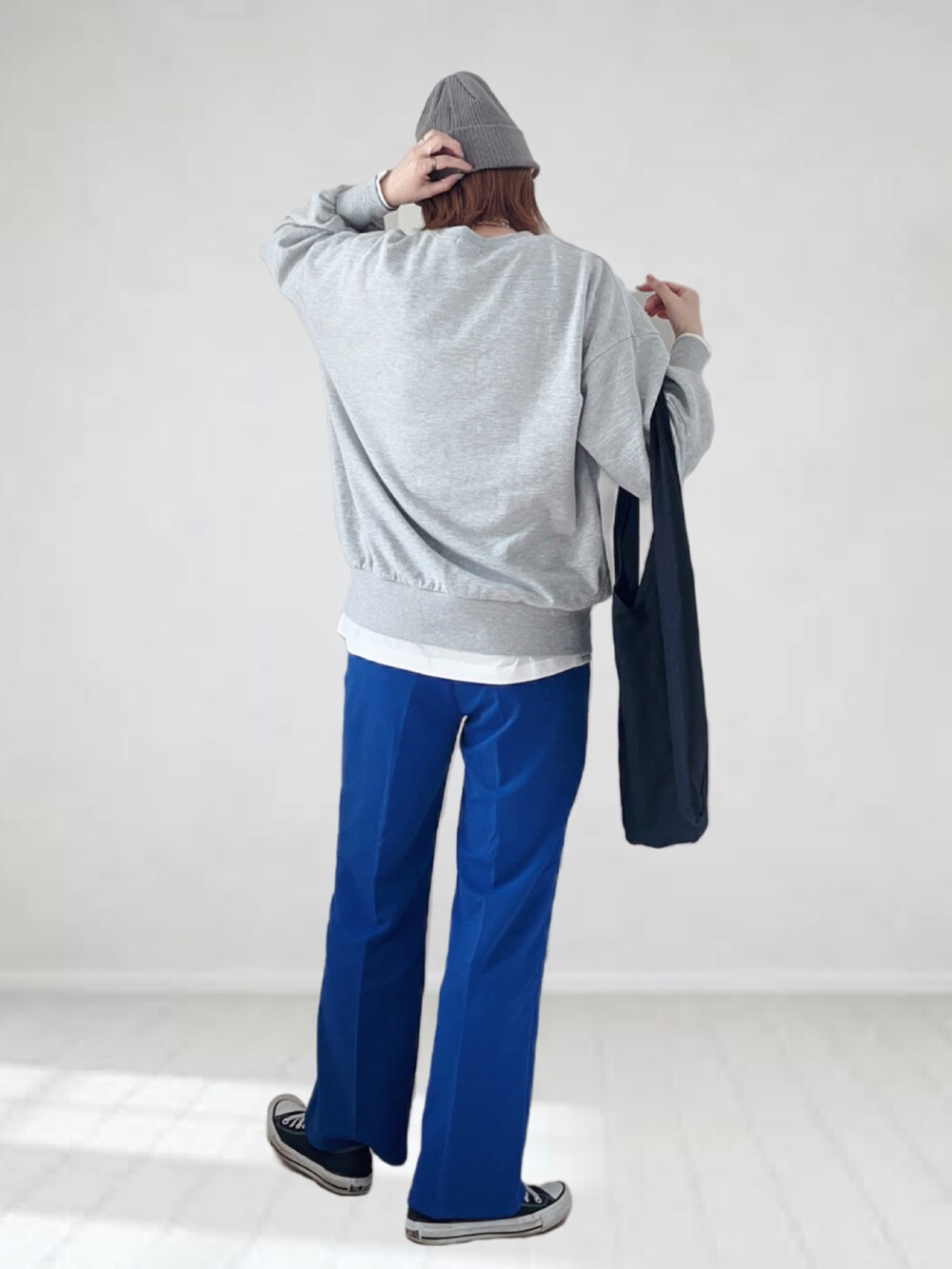 グレー系のスウェット、ブルー系のスラックス、ブラック系のトートバッグを着用したレディースの春コーディネートの3枚目の写真