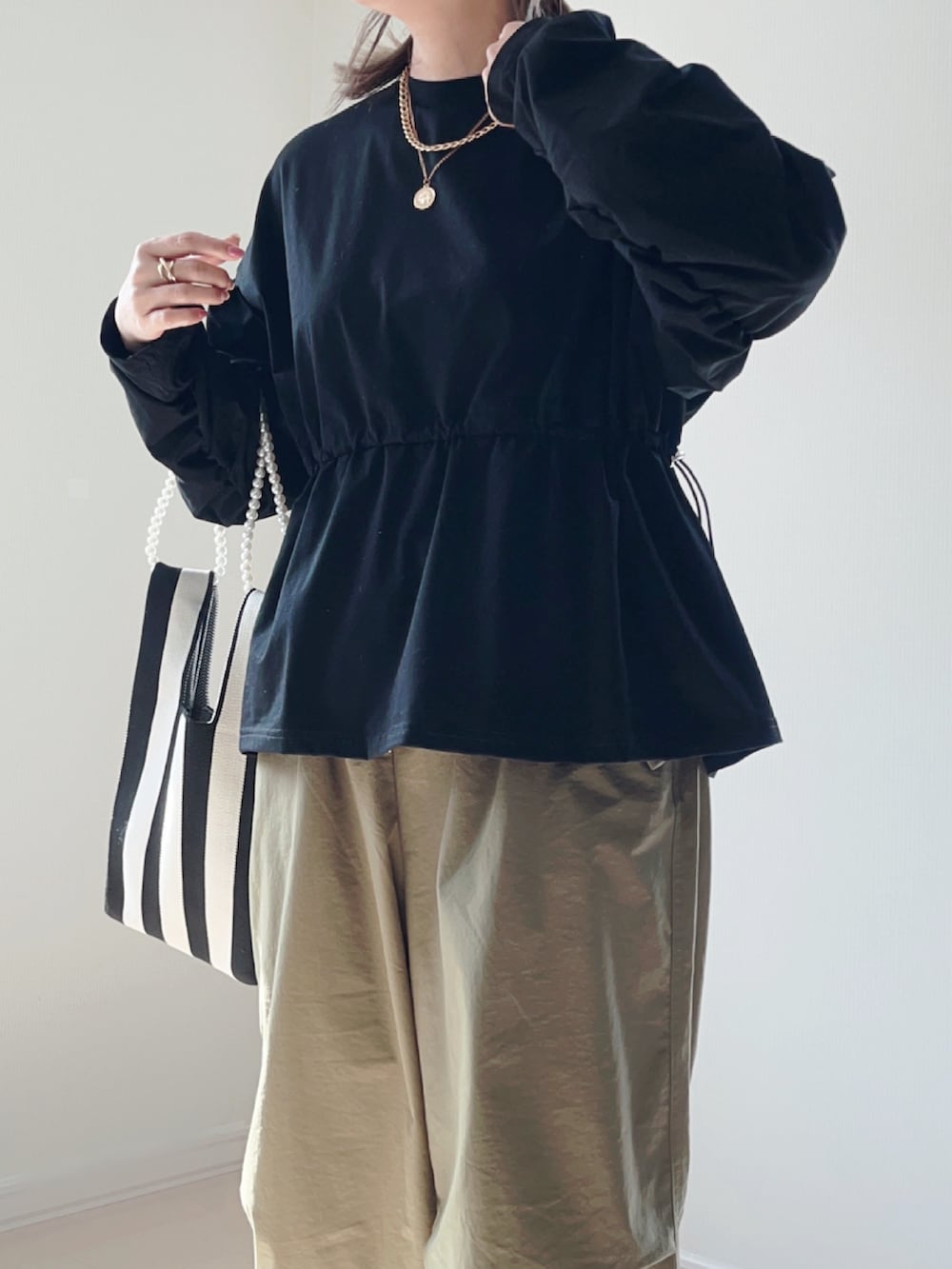 ブラック系のTシャツ/カットソー、グリーン系のその他パンツ、ホワイト系のショルダーバッグを着用したレディースの春コーディネートの4枚目の写真