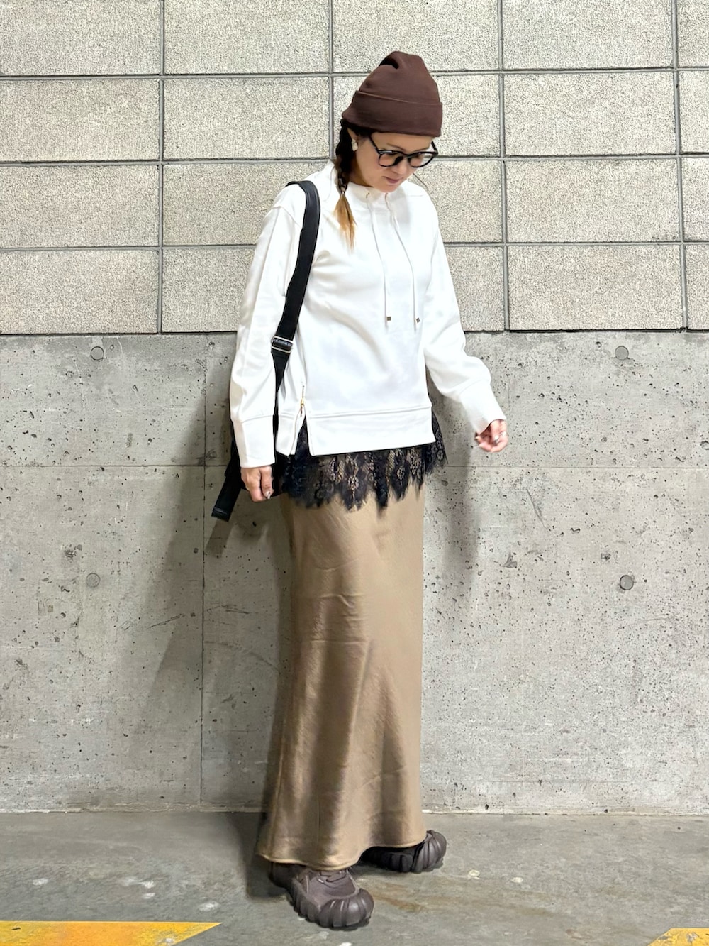 ホワイト系のスウェット、ブラウン系のスニーカー、ブラック系のショルダーバッグを着用したレディースの春コーディネートの2枚目の写真