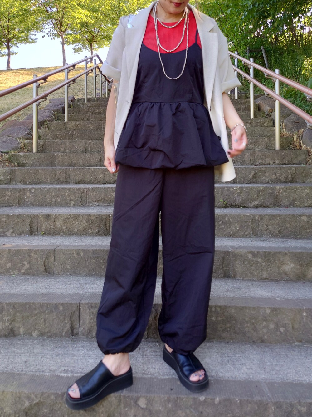 ブラック系のサロペット/オーバーオール、ホワイト系のテーラードジャケット、レッド系のTシャツ/カットソーを着用したレディースの夏コーディネートの3枚目の写真