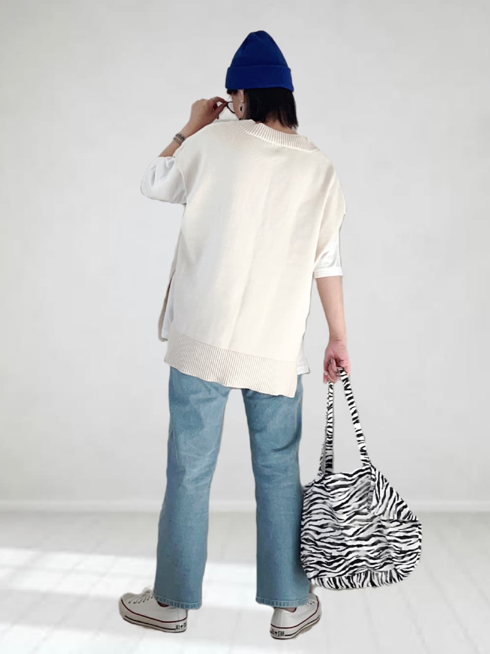 ブルー系のデニムパンツ、ホワイト系のベスト、ホワイト系のTシャツ/カットソーを着用したレディースの夏コーディネートの3枚目の写真