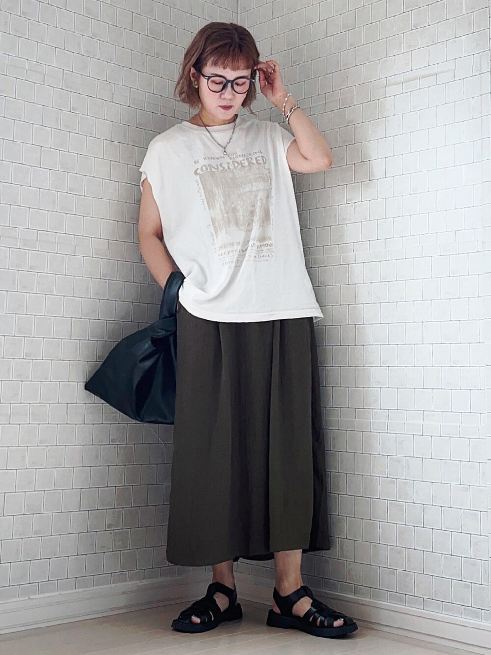 グリーン系のその他パンツ、ホワイト系のTシャツ/カットソー、ブラック系のサンダルを着用したレディースの夏コーディネートの2枚目の写真