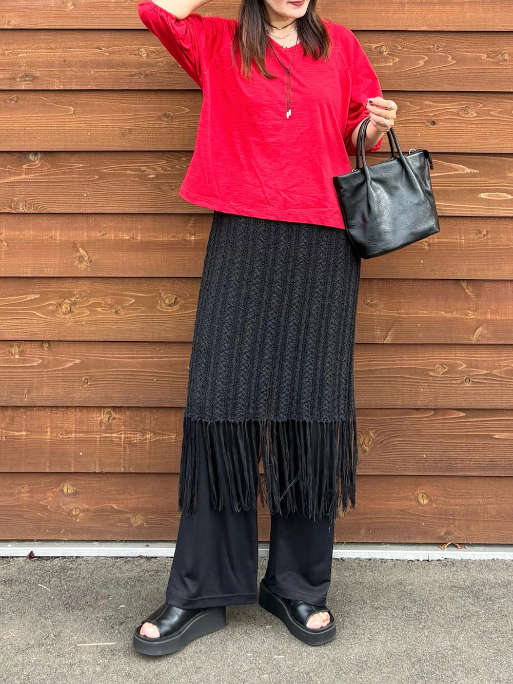レッド系のTシャツ/カットソー、ブラック系のその他パンツ、ブラック系のスカートを着用したレディースの夏コーディネートの2枚目の写真