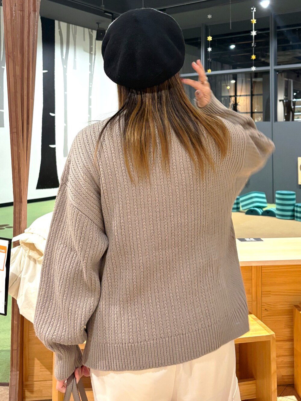 ブラウン系のニット/セーター、ホワイト系のその他パンツ、ベージュ系のショルダーバッグを着用したレディースの冬コーディネートの4枚目の写真