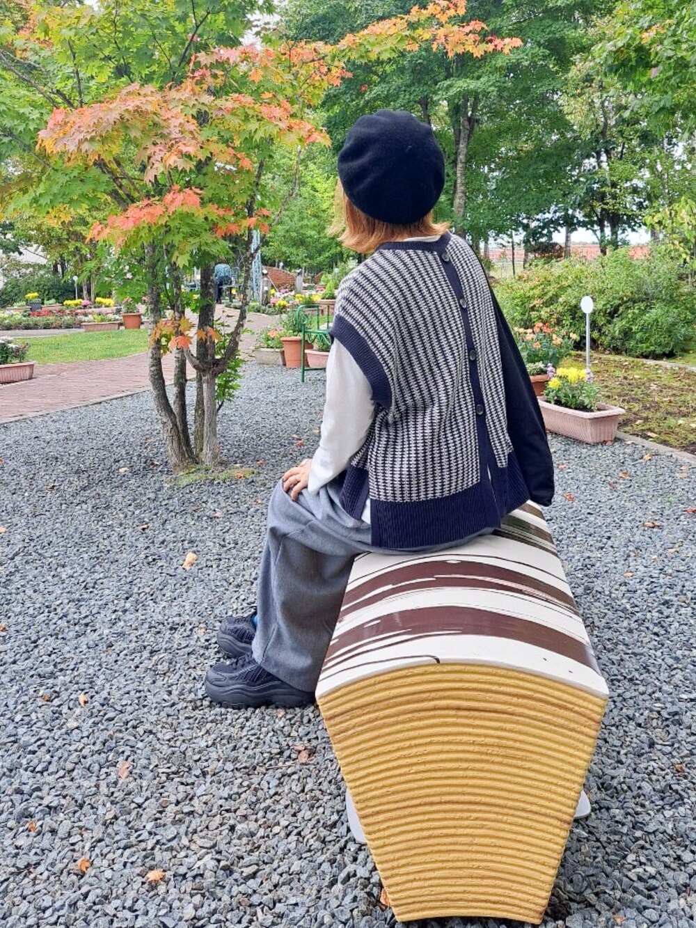 ブルー系のニット/セーター、グレー系のその他パンツ、ブラック系のスニーカーを着用したレディースの秋コーディネートの4枚目の写真