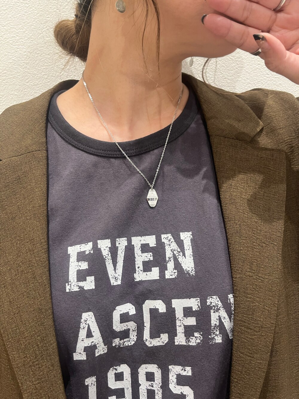 ブラウン系のテーラードジャケット、グレー系のTシャツ/カットソー、ブルー系のデニムパンツを着用したレディースの夏コーディネートの3枚目の写真
