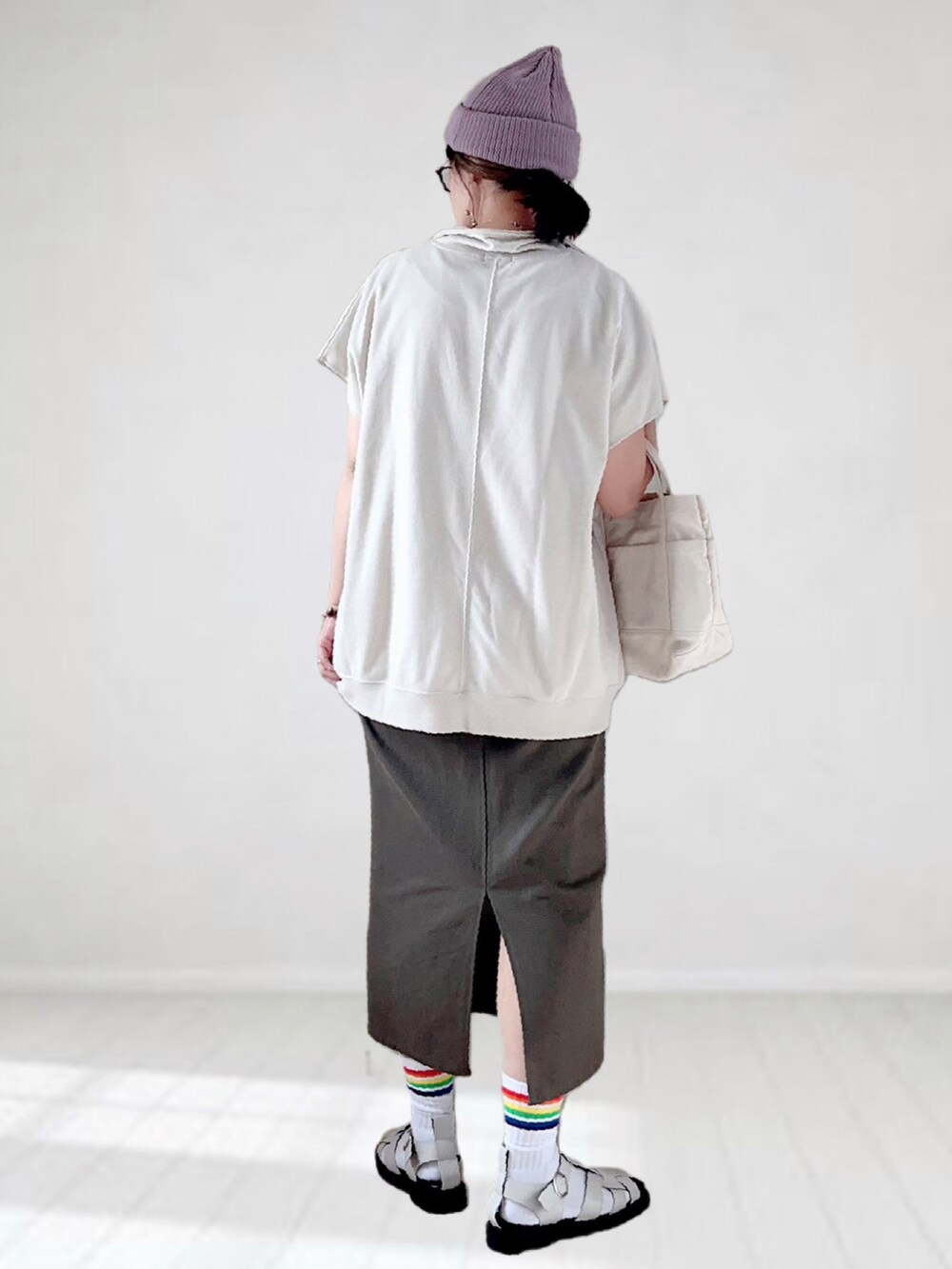 ベージュ系のTシャツ/カットソー、グレー系のスカート、ホワイト系のトートバッグを着用したレディースの春コーディネートの4枚目の写真