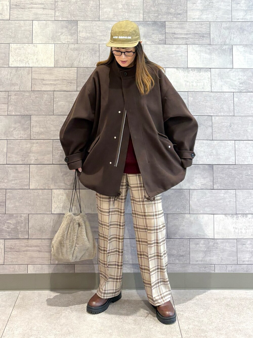 ブラウン系のモッズコート、レッド系のニット/セーター、ベージュ系のその他パンツを着用したレディースの冬コーディネートの2枚目の写真