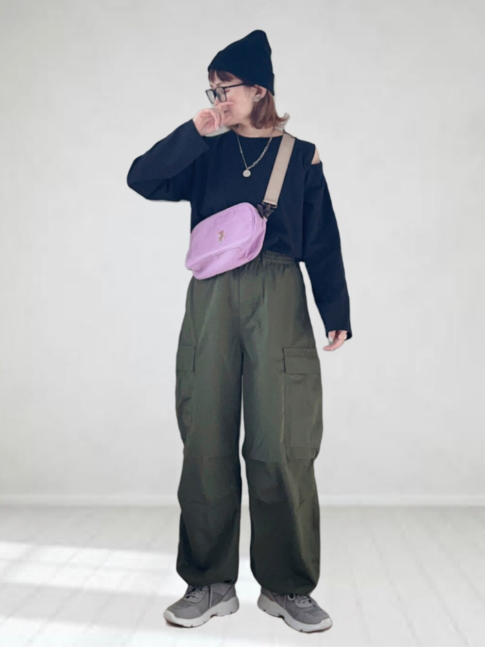 グリーン系のカーゴパンツ、ブラック系のTシャツ/カットソー、パープル系のショルダーバッグを着用したレディースの春コーディネートの2枚目の写真