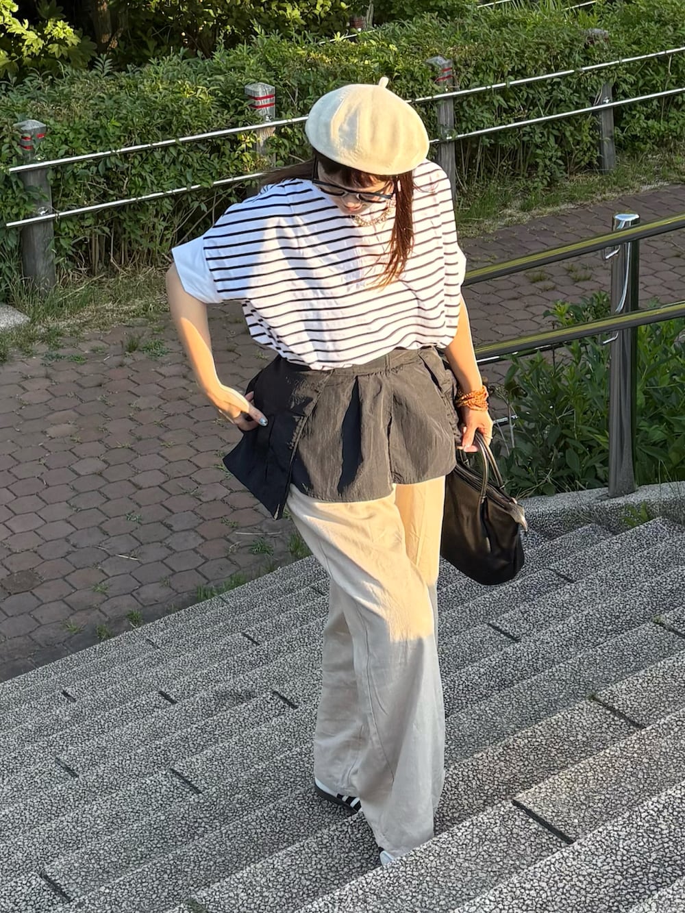 ベージュ系のその他パンツ、ホワイト系のTシャツ/カットソー、ホワイト系のスニーカーを着用したレディースの夏コーディネートの2枚目の写真