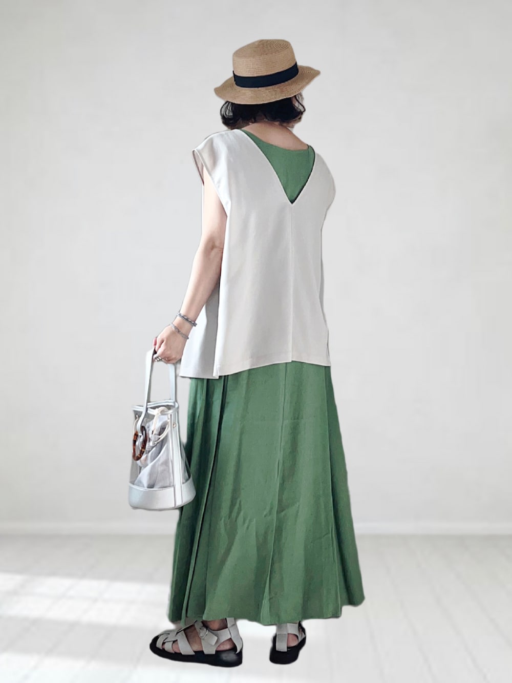 グリーン系のワンピース、ベージュ系のベスト、シルバー系のショルダーバッグを着用したレディースの夏コーディネートの3枚目の写真