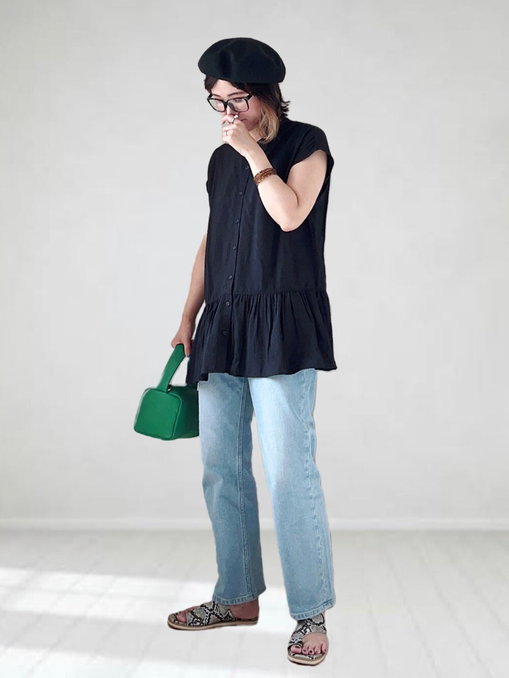 ブルー系のデニムパンツ、ブラック系のシャツ/ブラウス、グリーン系のショルダーバッグを着用したレディースの夏コーディネートの2枚目の写真