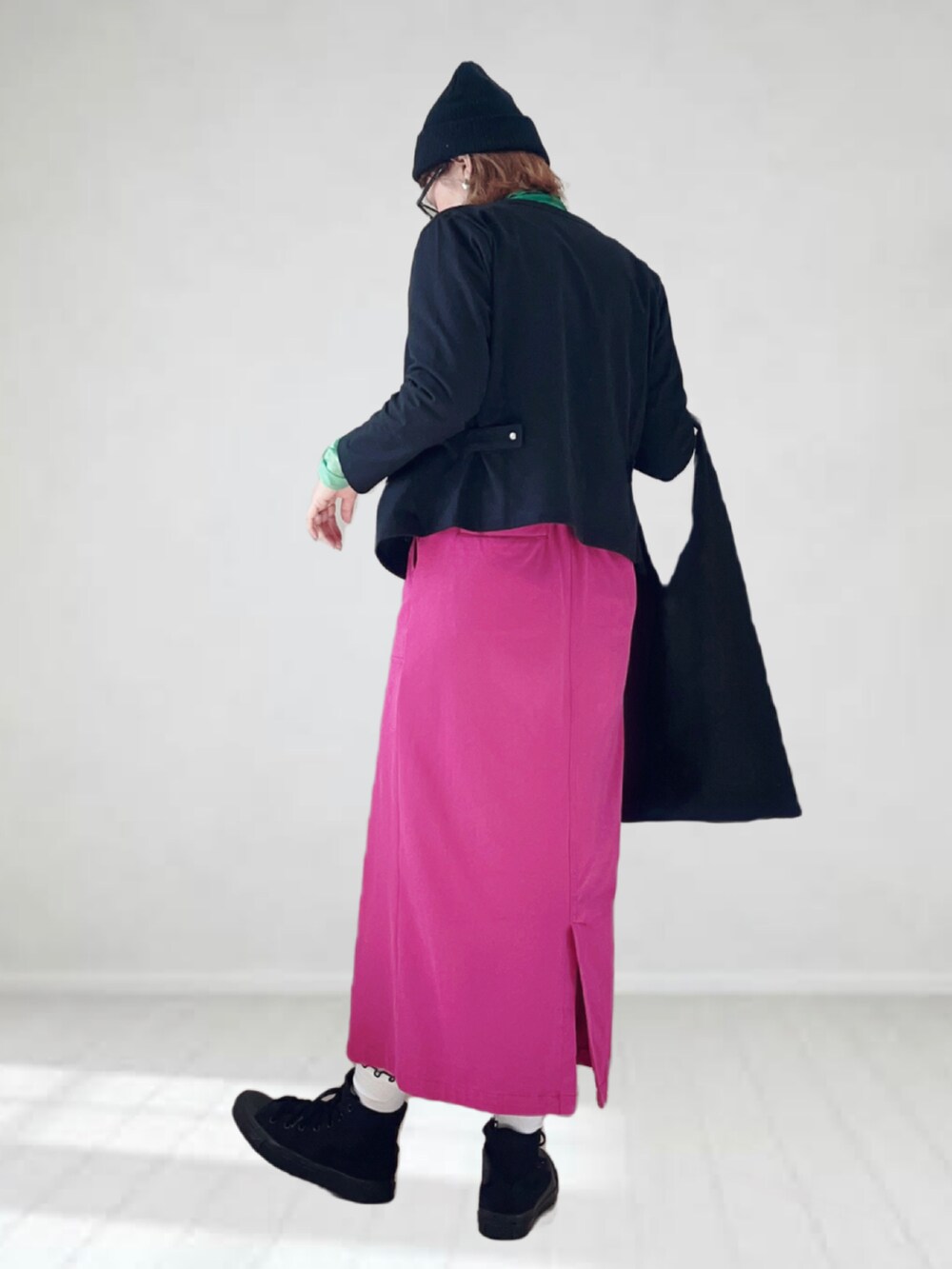 ブラック系のカーディガン/ボレロ、グリーン系のTシャツ/カットソー、パープル系のスカートを着用したレディースの春コーディネートの3枚目の写真