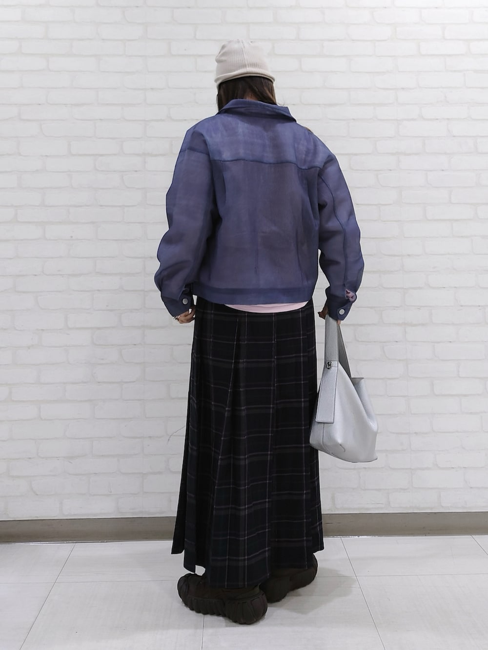 ブルー系のデニムジャケット、ブルー系のスカート、ブラウン系のスニーカーを着用したレディースの春コーディネートの3枚目の写真