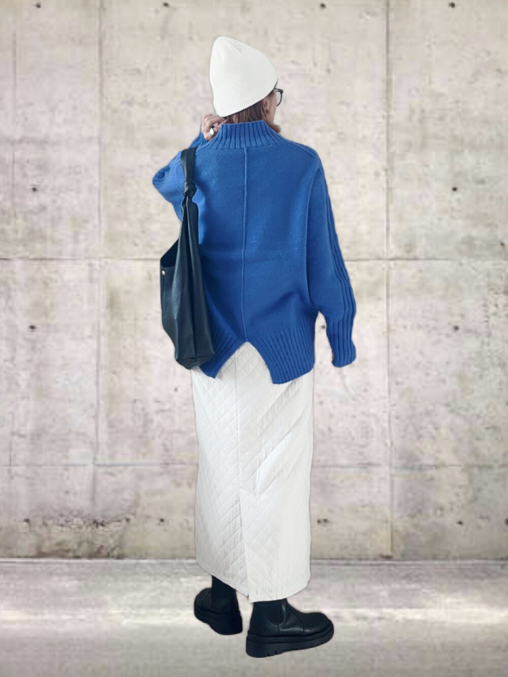 ブルー系のニット/セーター、ホワイト系のスカート、ブラック系のトートバッグを着用したレディースの冬コーディネートの3枚目の写真