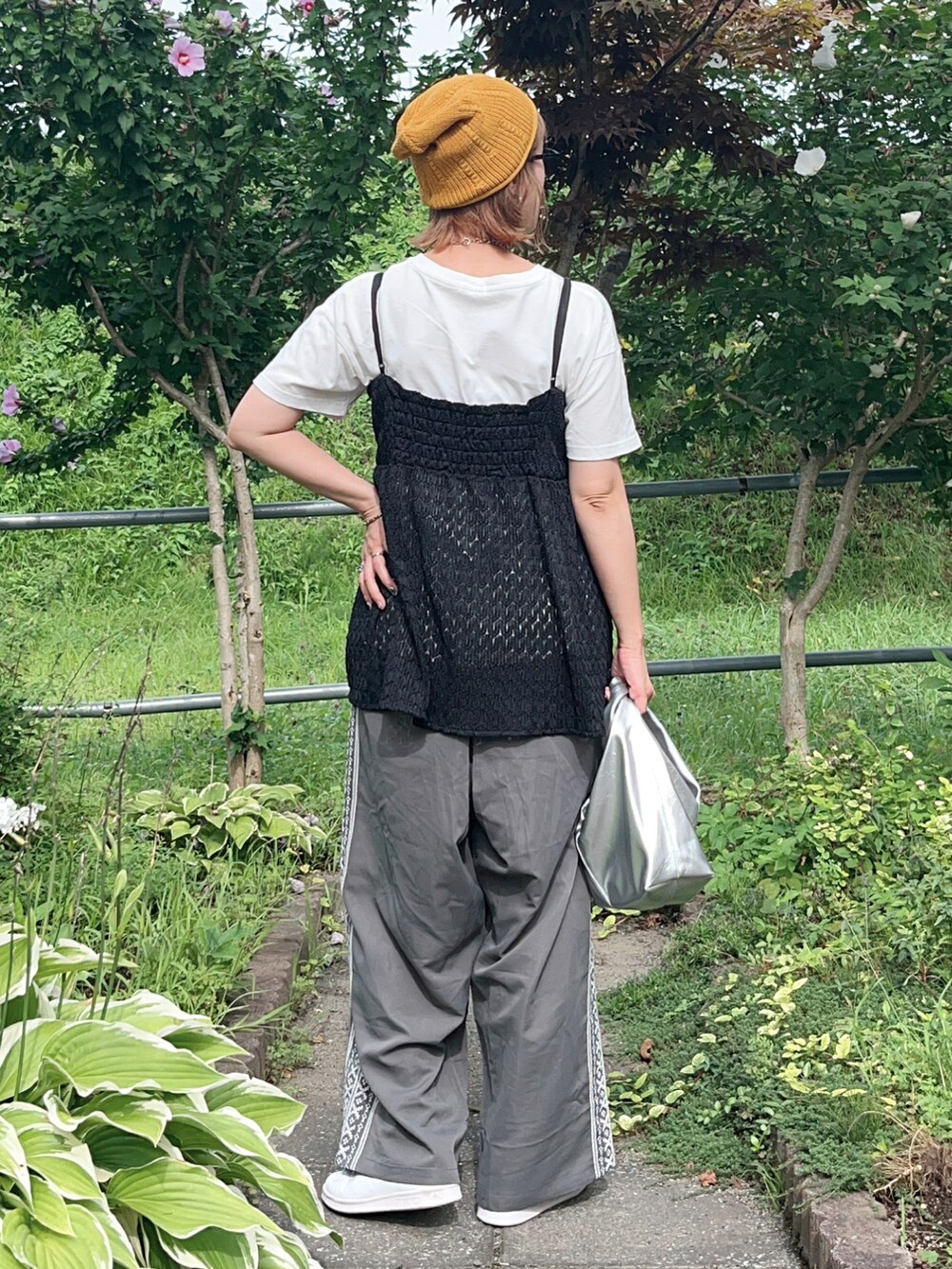 グレー系のその他パンツ、ブラック系のTシャツ/カットソー、ホワイト系のスニーカーを着用したレディースの夏コーディネートの5枚目の写真