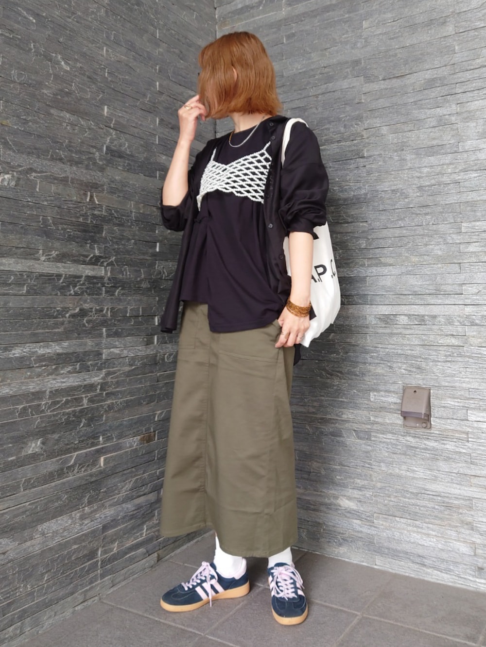 グリーン系のスカート、ブラック系のシャツ/ブラウス、ブラック系のTシャツ/カットソーを着用したレディースの秋コーディネートの2枚目の写真
