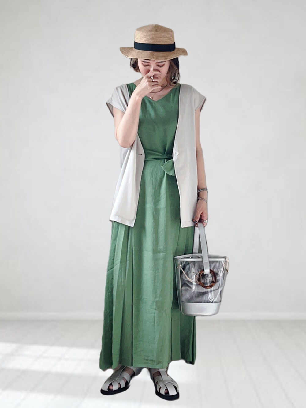 グリーン系のワンピース、ベージュ系のベスト、シルバー系のショルダーバッグを着用したレディースの夏コーディネートの2枚目の写真