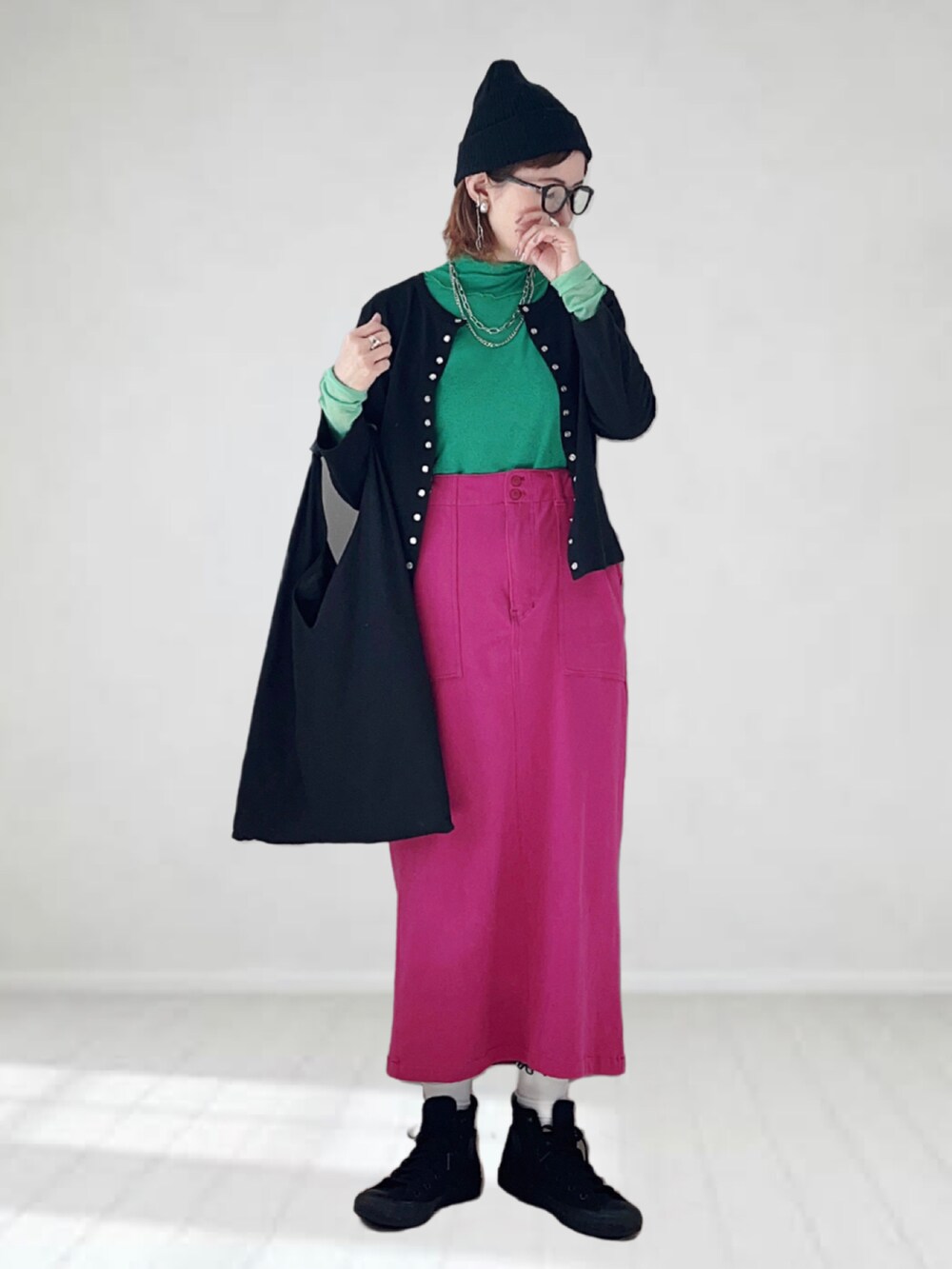 ブラック系のカーディガン/ボレロ、グリーン系のTシャツ/カットソー、パープル系のスカートを着用したレディースの春コーディネートの2枚目の写真