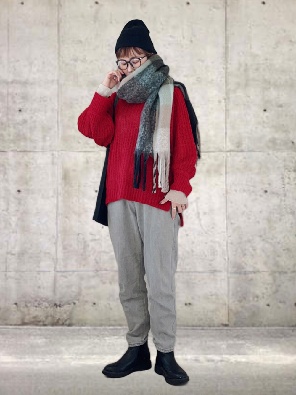 レッド系のニット/セーター、ベージュ系のデニムパンツ、ブラック系のトートバッグを着用したレディースの冬コーディネートの2枚目の写真
