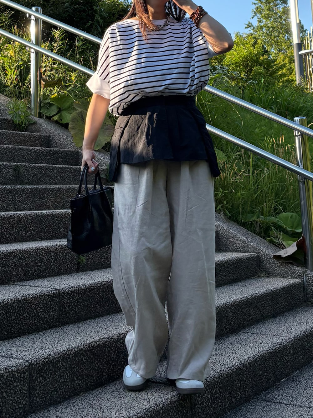 ベージュ系のその他パンツ、ホワイト系のTシャツ/カットソー、ホワイト系のスニーカーを着用したレディースの夏コーディネートの5枚目の写真